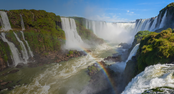 Cataratas del Iguazú de fondo con terminal roja de Getnet con logo Visa en la pantalla en el margen inferior derecho.